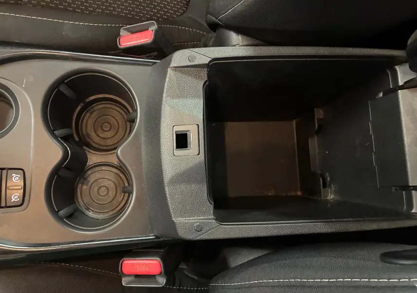 Vue plongeante sur la console centrale noire du Renault Kadjar 2019, avec porte-gobelets et rangement ouvert.