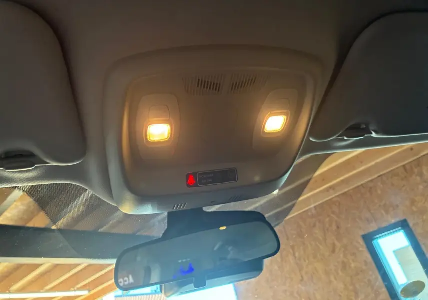 Vue intérieure du plafonnier avec éclairage allumé et rétroviseur dans un Renault Kadjar gris 2019.