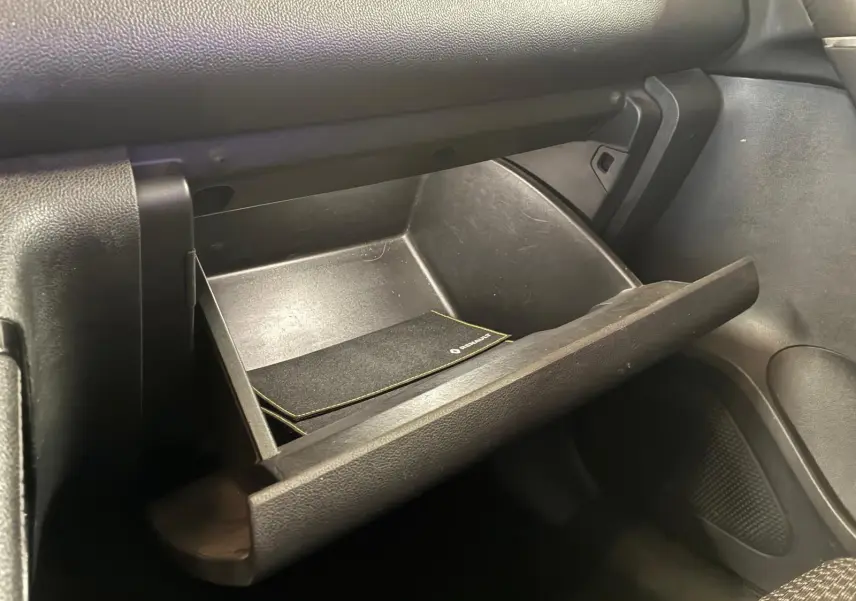 Gros plan sur la boîte à gants ouverte du Renault Kadjar 2019, intérieur noir avec manuel de bord visible.