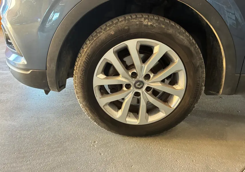 Gros plan sur la roue avant gauche gris métallisé du Renault Kadjar 2019 avec jante alliage et logo Renault central.