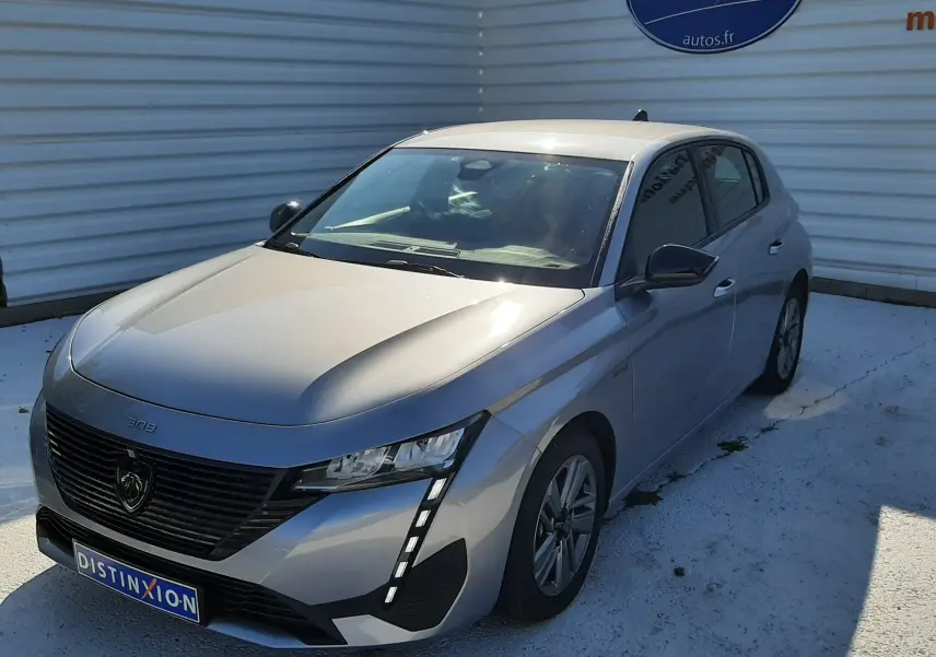 Peugeot 308 III Hybrid gris Artense vue 3/4 avant droit, avec calandre noire et feux LED verticaux distinctifs.