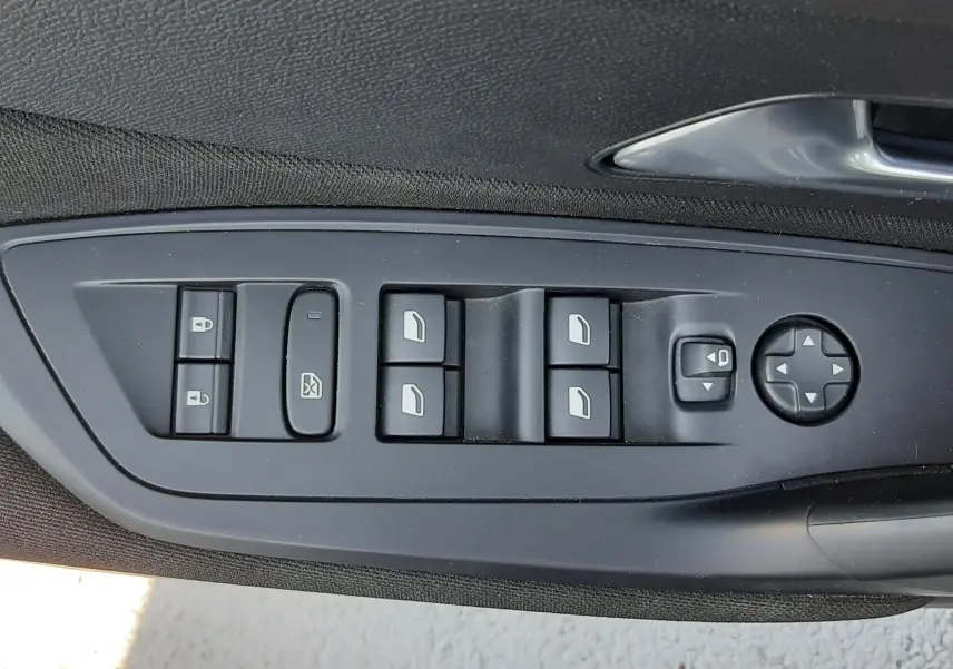 Commande des vitres et rétroviseurs côté conducteur de la Peugeot 308 III Hybrid 145ch Style en intérieur noir.