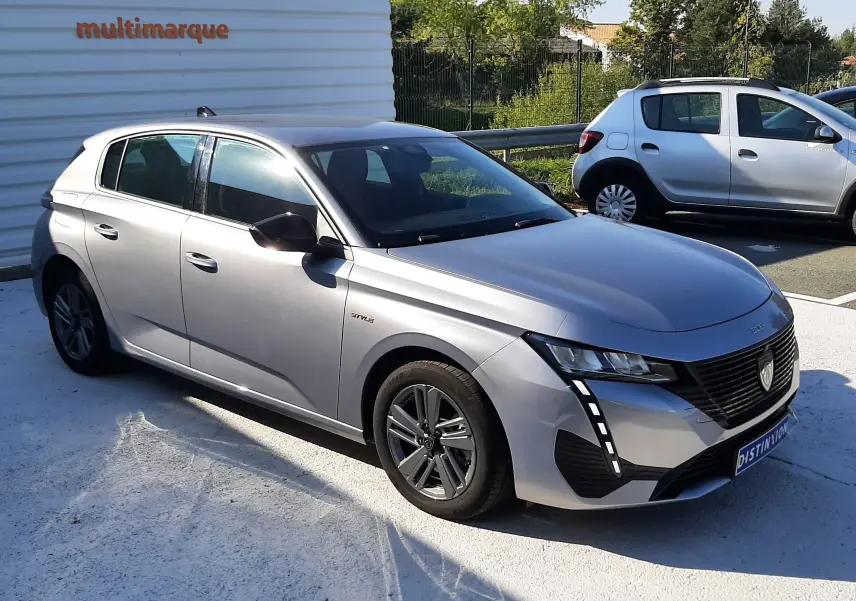 PEUGEOT 308 III HYBRID gris Artense en 3/4 avant droit, avec feux LED et jantes alliage 16 pouces visibles.