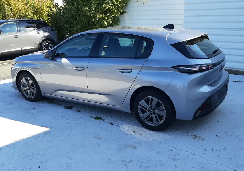 Peugeot 308 III Hybrid gris Artense vue 3/4 arrière côté gauche, avec feux arrière LED et jantes alliage.