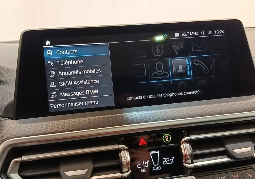 Écran tactile central intérieur du BMW X3 blanc 2023 affichant le menu contacts et options connectées.