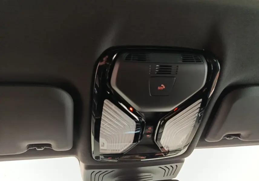 Plafonnier intérieur noir avec bouton SOS et éclairage LED, vue du toit d’un BMW X3 blanc hybride rechargeable.