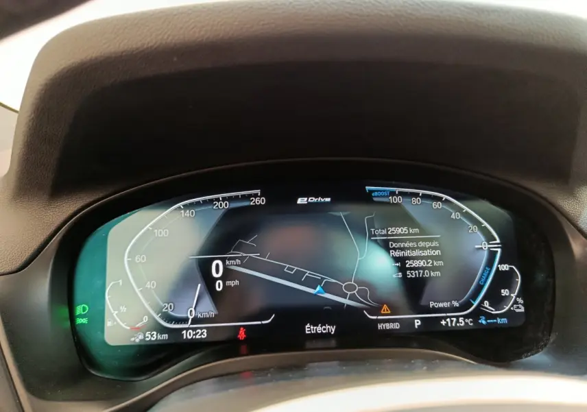 Tableau de bord numérique de BMW X3 blanc, affichage 12,3 pouces avec navigation et indicateurs hybrides.