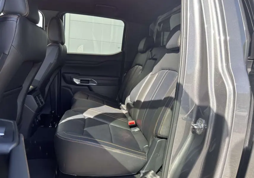 Vue intérieure côté droit sur la banquette arrière en cuir noir avec surpiqûres contrastantes du Ford Ranger gris carbone.