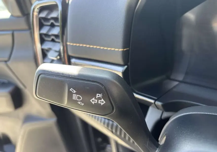 Gros plan sur la manette de clignotants à gauche du volant dans l’habitacle du Ford Ranger gris carbone 2026.