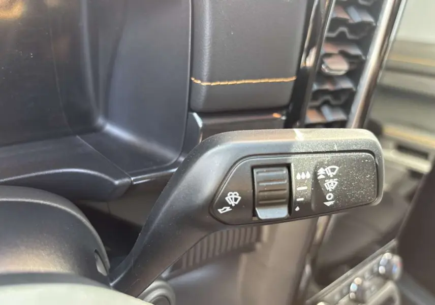 Gros plan sur la commande des essuie-glaces du Ford Ranger gris carbone, intérieur avec coutures jaunes visibles.