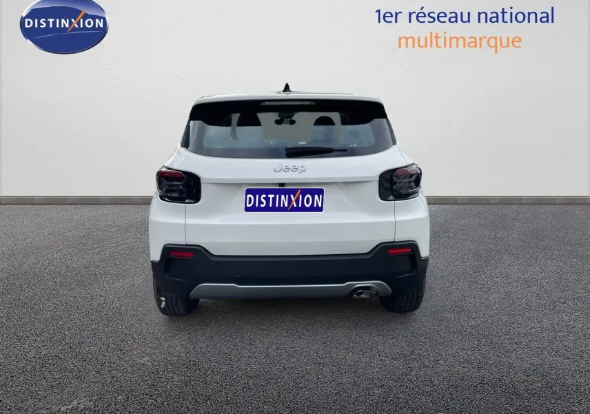 Vue arrière d'un Jeep Avenger blanc neige 2024 avec feux arrière fumés et une sortie d'échappement visible côté droit.