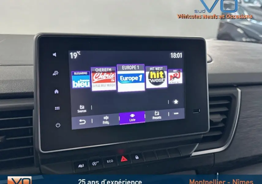 Écran tactile multimédia du Renault Trafic Fourgon gris 2025, affichant les stations radio avec commandes en dessous.