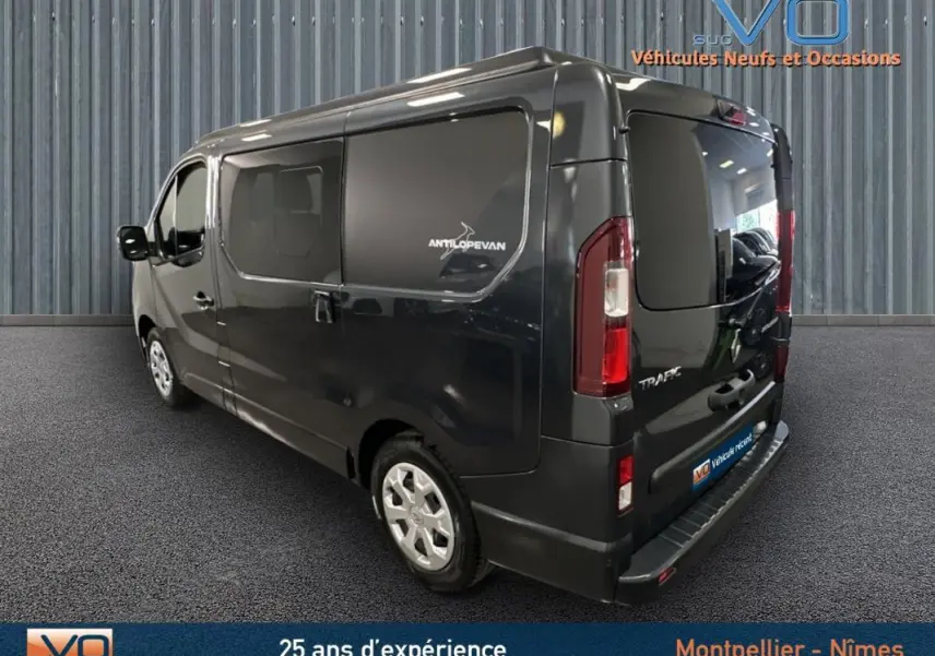 Vue 3/4 arrière droite du Renault Trafic Fourgon gris 2025 avec vitres surteintées et logo Antilopevan sur la porte latérale.