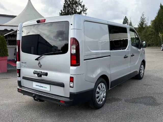 Vue 3/4 arrière droite du Renault Trafic Fourgon gris platine avec vitres teintées et hayon arrière vitré.