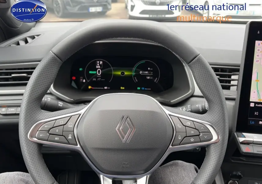 Vue intérieure centrée sur le volant perforé de Renault Captur 2026 avec tableau de bord numérique et écran tactile latéral.