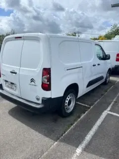 Vue 3/4 arrière droite d’un Citroën Berlingo XL blanc banquise, fourgon utilitaire avec portes arrière pleines, stationné en extérieur.