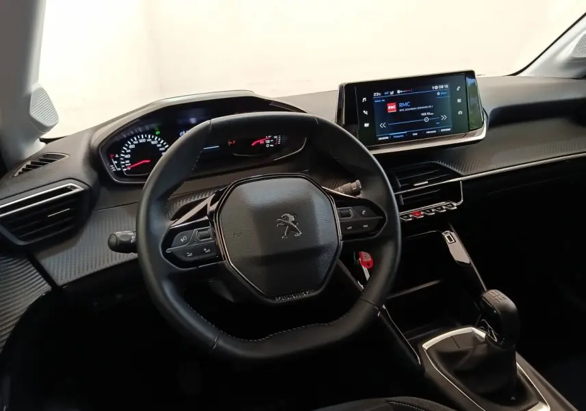 Vue intérieure centrée sur le volant cuir et tableau de bord numérique de la Peugeot 208 PureTech 75 S&S Style.