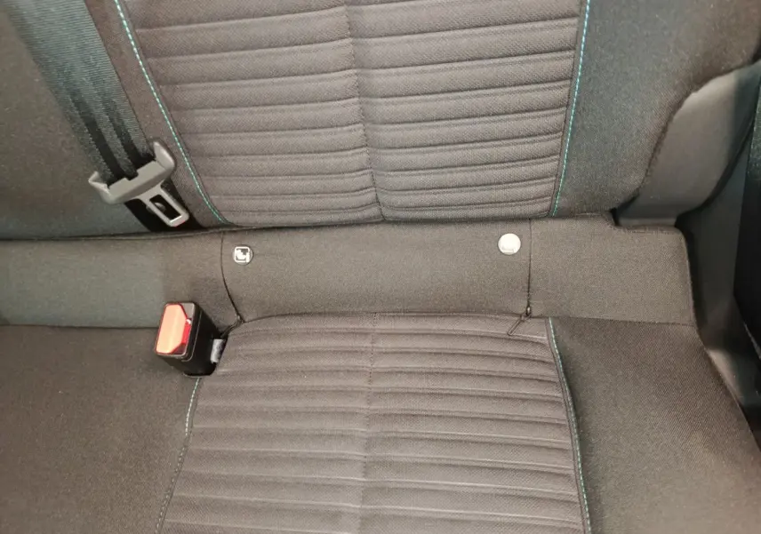 Gros plan sur la banquette arrière noire de la Peugeot 208 2023 avec surpiqûres bleues et ceinture de sécurité visible.