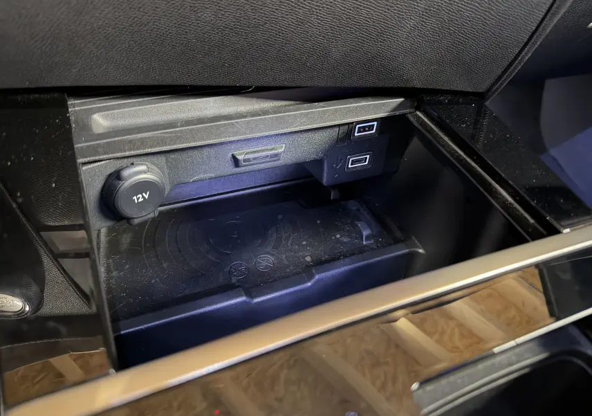 Gros plan sur la console centrale noire de l’Opel Astra 2024 avec prise 12V et deux ports USB visibles.
