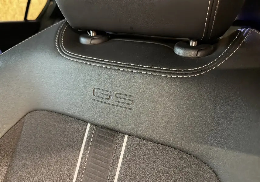Gros plan sur le dossier de siège avant en cuir noir avec logo GS embossé dans l’habitacle de l’Opel Astra.