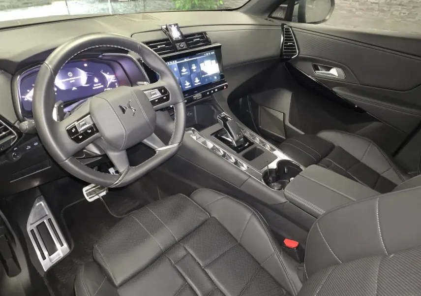 Vue intérieure côté conducteur du DS7 Crossback 2025 en cuir noir avec écran tactile et volant multifonction.