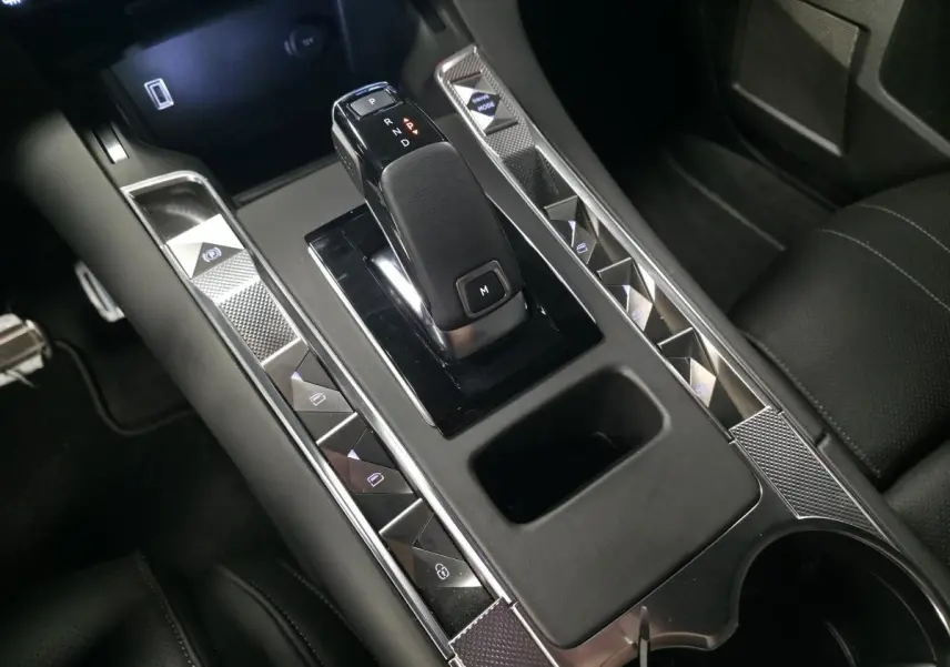 Gros plan sur la console centrale noire du DS7 Crossback 2025 avec levier de vitesse automatique et commandes tactiles.