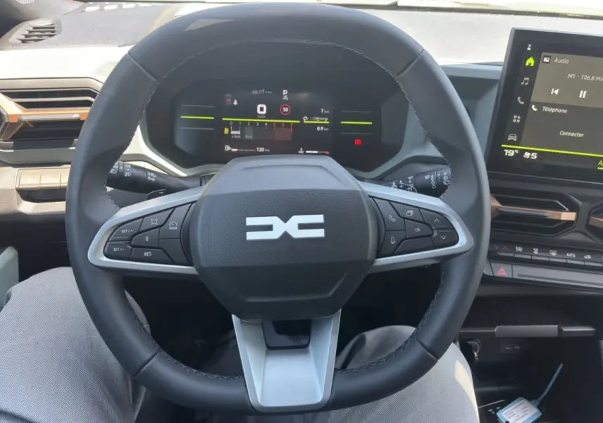 Vue intérieure centrée sur le volant cuir du Dacia Duster 2026 avec tableau de bord digital et écran tactile.