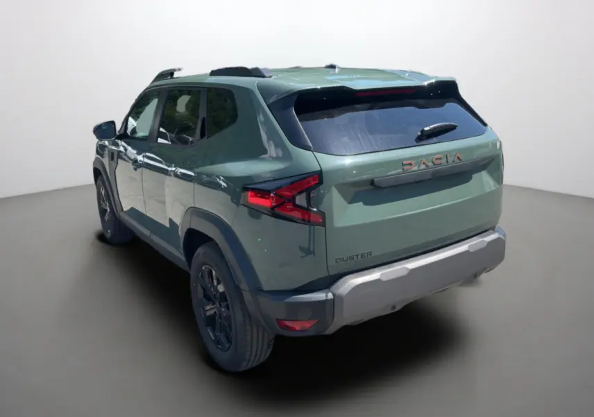 Vue 3/4 arrière droite d’un Dacia Duster 2026 kaki lichen avec barres de toit et jantes alu noires.