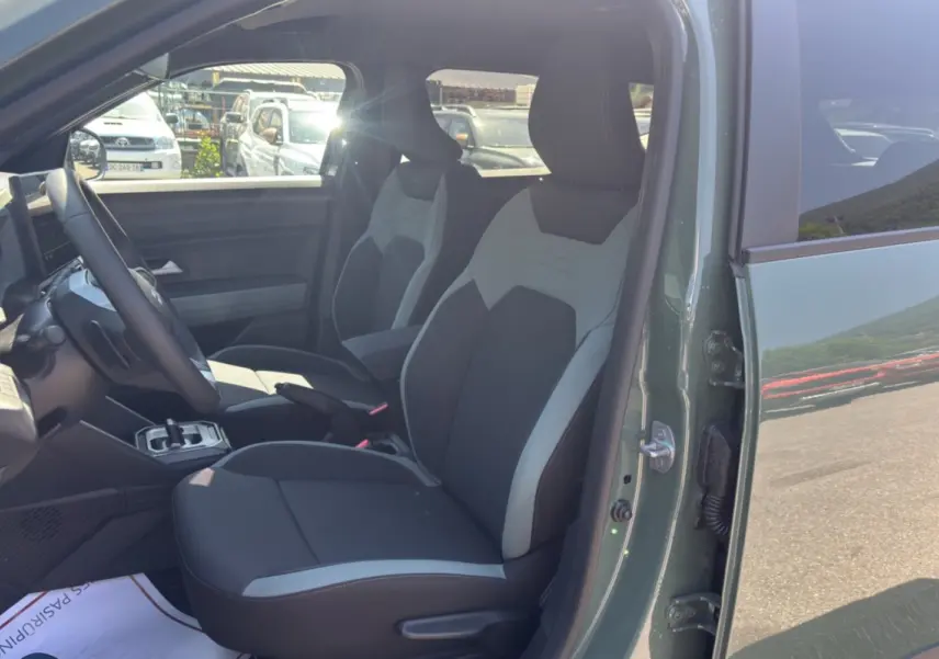 Vue intérieure côté conducteur du Dacia Duster 2026 kaki lichen, montrant les sièges avant et le volant.