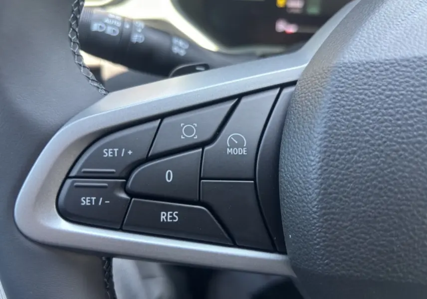 Gros plan sur les commandes de régulateur de vitesse au volant noir du Dacia Duster 2026, finition Extreme PK City.