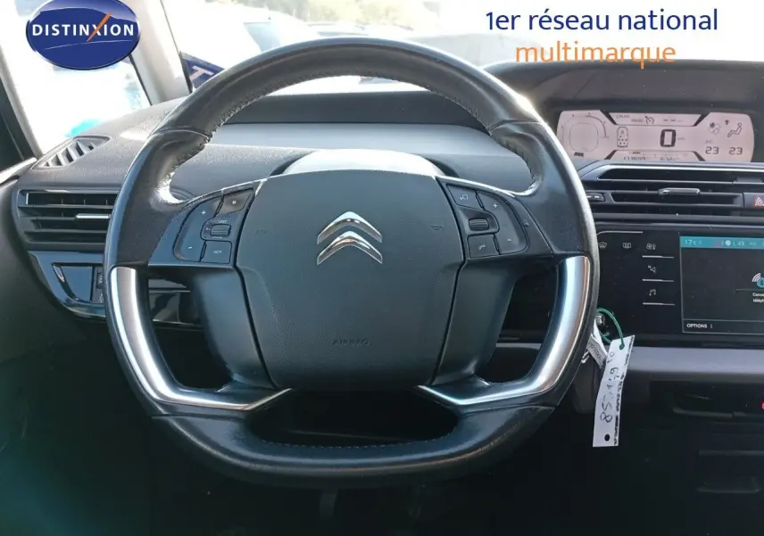 Volant cuir noir avec commandes intégrées du Citroën Grand C4 Picasso II Diesel, vue frontale de l'habitacle.
