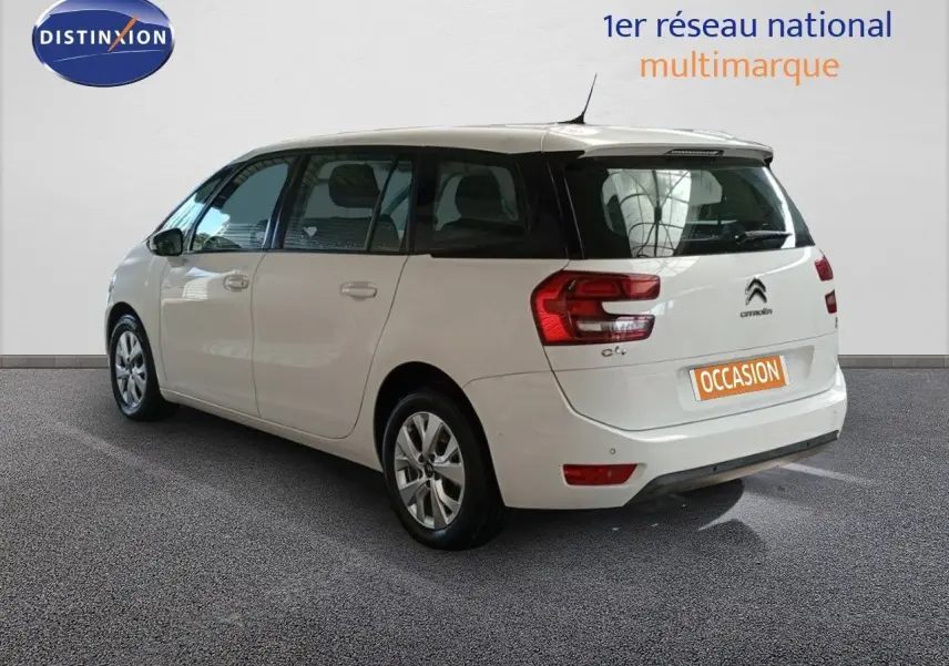 Vue 3/4 arrière gauche d'un Citroën Grand C4 Picasso blanc avec feux arrière distinctifs et cinq portes.