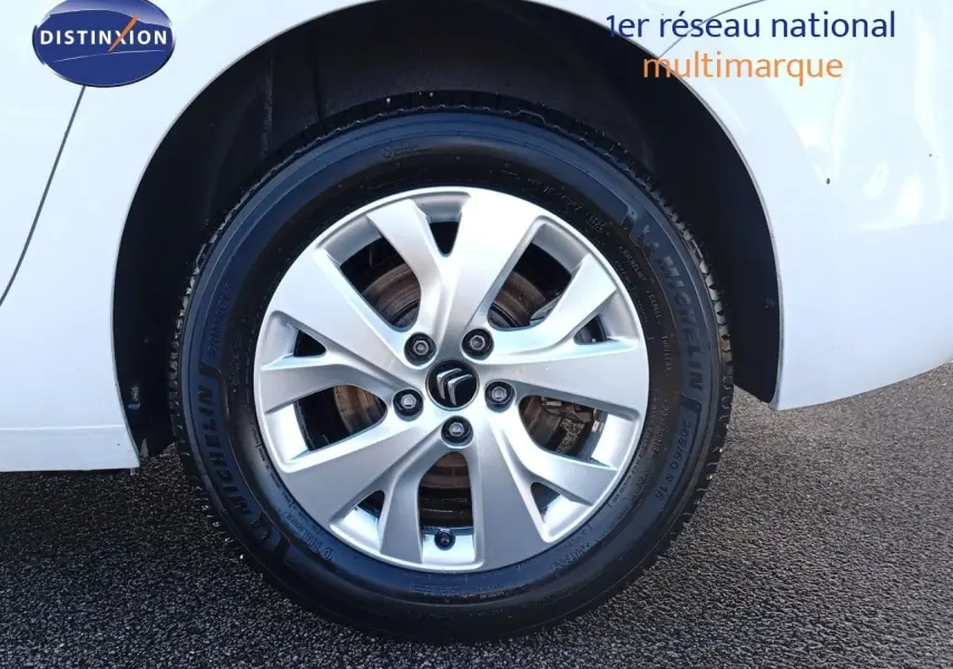 Gros plan sur la roue avant gauche blanche d'un Citroën Grand C4 Picasso II avec jante alliage et pneu Michelin.