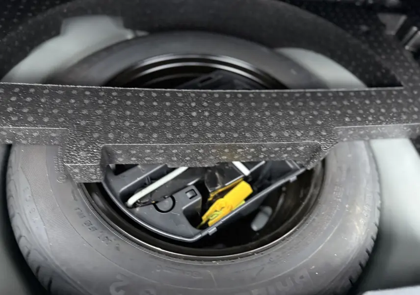 Gros plan sur la roue de secours et les outils de bord dans le coffre d’un Peugeot 2008 noir GT Line 2018.