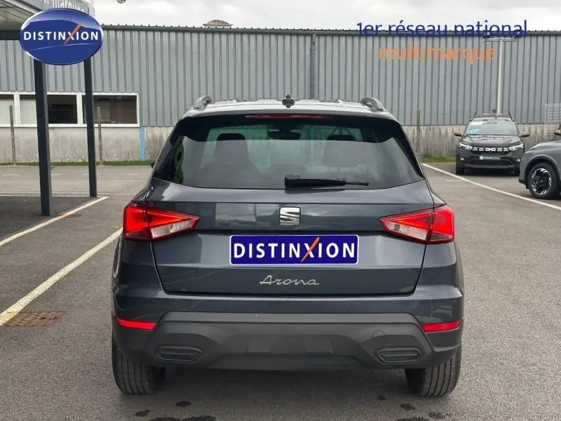 Vue arrière d'un SEAT Arona 2025 gris Magnétique Métal avec toit noir, mettant en valeur ses feux arrière anguleux.