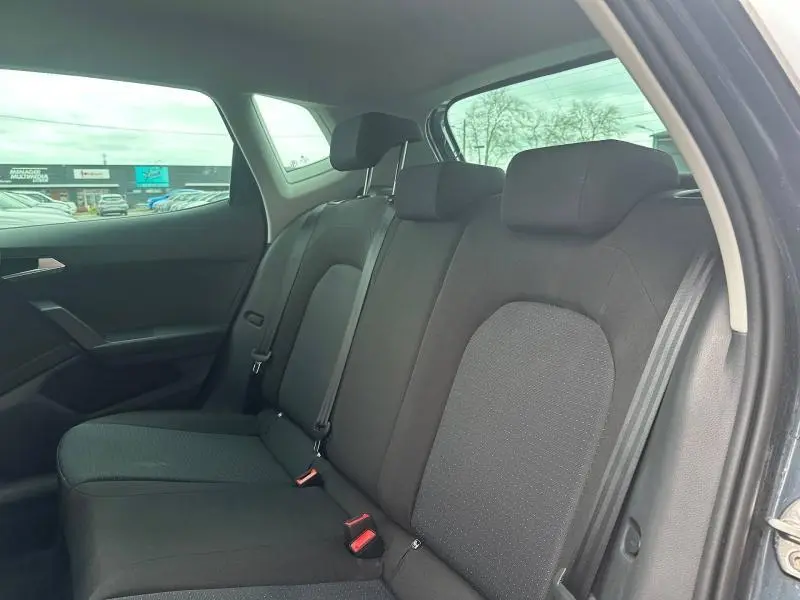 Vue intérieure côté droit des sièges arrière noirs du SEAT Arona 2025 avec ceintures et appuie-têtes visibles.