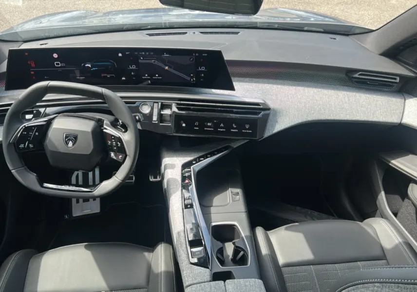 Vue intérieure avant du Peugeot 5008 Hybrid 145 GT 7 places, volant cuir multifonctions et tableau de bord numérique large.