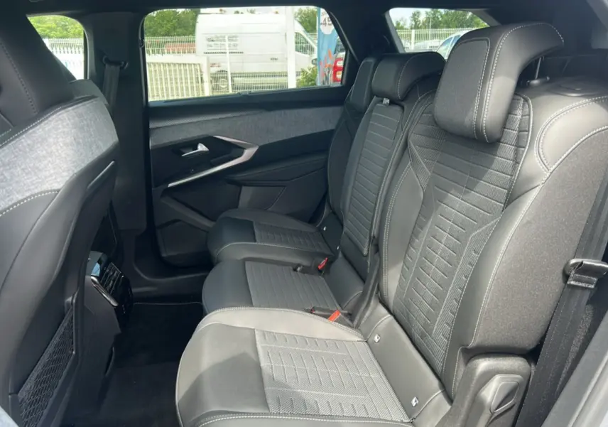 Vue latérale droite de la banquette arrière en cuir et tissu gris du Peugeot 5008 Hybrid 145 GT 7 places, intérieur spacieux.
