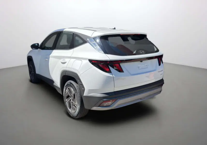 Vue 3/4 arrière gauche du Hyundai Tucson blanc atlas 2026 avec feux arrière LED et jantes alu 17 pouces.