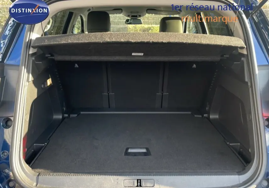 Coffre ouvert vu de l'arrière d'un Citroën C5 Aircross bleu Eclipse Métal, montrant un espace de chargement vide.