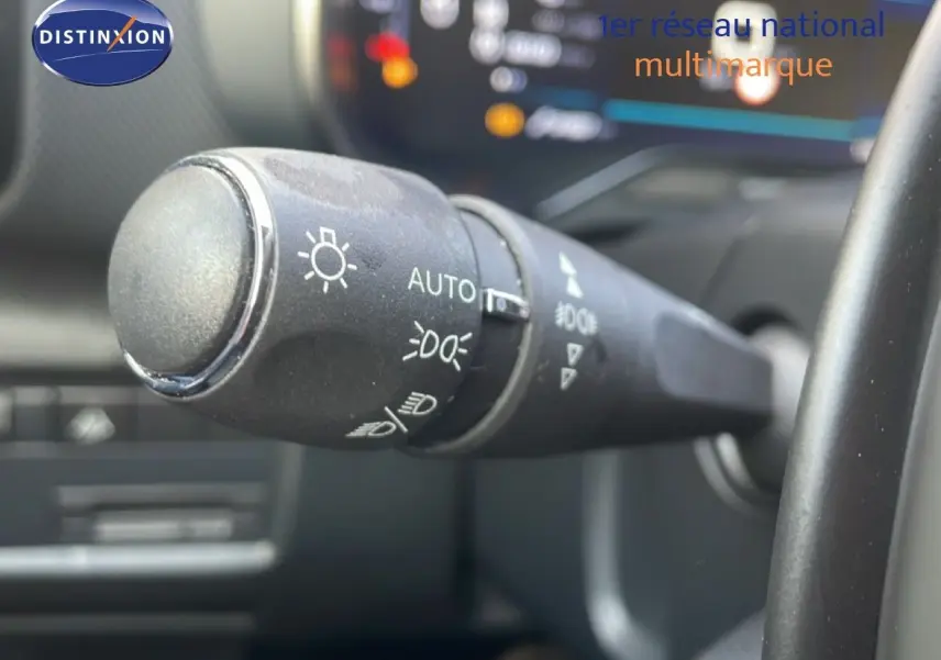 Gros plan sur la commande des feux automatique dans l'habitacle d'une Citroën C5 Aircross 2023 bleu Eclipse Metal.