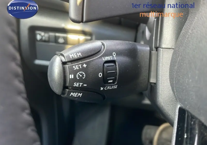 Gros plan sur la commande de régulateur de vitesse du Citroën C5 Aircross 2023, intérieur noir.