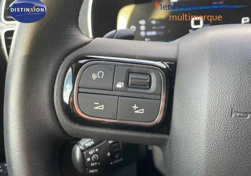 Détail du volant du Citroën C5 Aircross 2023 bleu Eclipse Metal, avec commandes audio et régulateur de vitesse visibles.