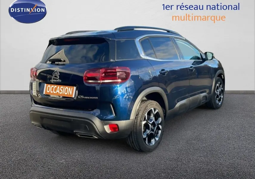 Vue 3/4 arrière droite d'un Citroën C5 Aircross bleu Eclipse Métal avec jantes bi-ton et toit noir.