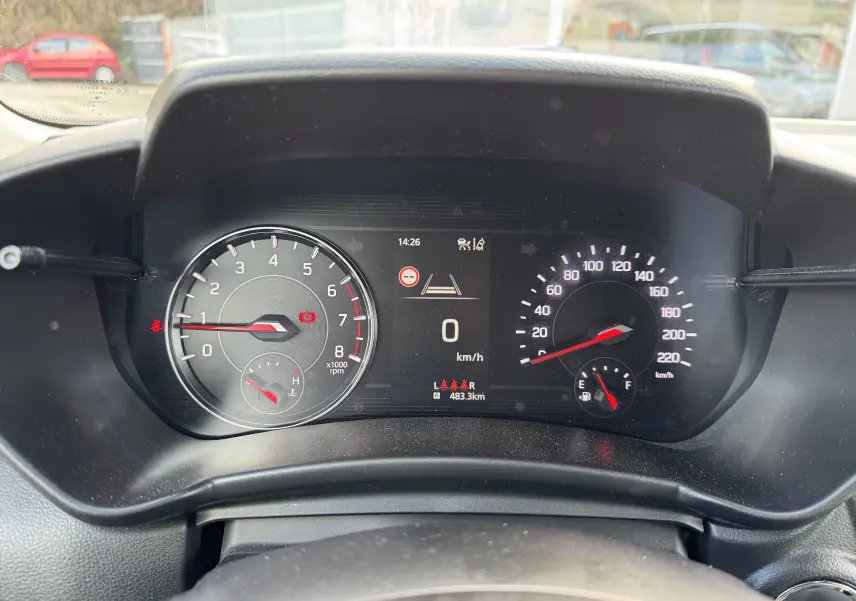 Vue rapprochée du tableau de bord de la Suzuki Swift gris, affichant le compteur de vitesse et le compte-tours numériques.