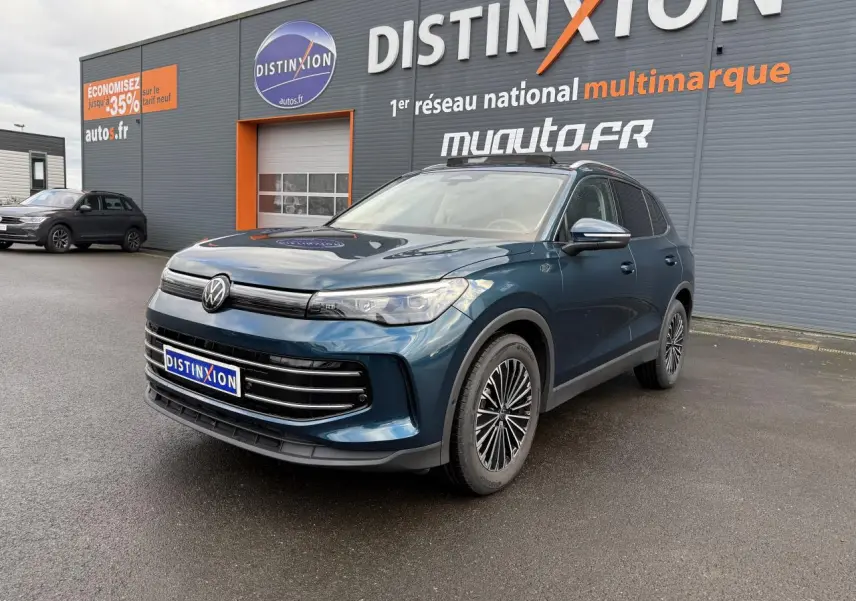 Volkswagen Tiguan 2024 bleu Nightshade en 3/4 avant droit, avec jantes alliage et calandre noire brillante.