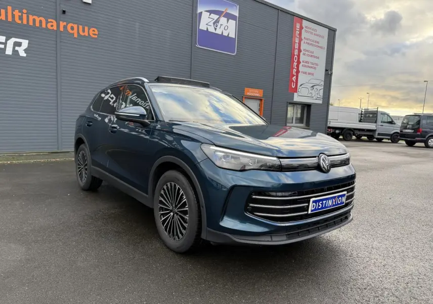 Volkswagen Tiguan 2024 bleu Nightshade, vue 3/4 avant droit, jantes alliage et calandre moderne.