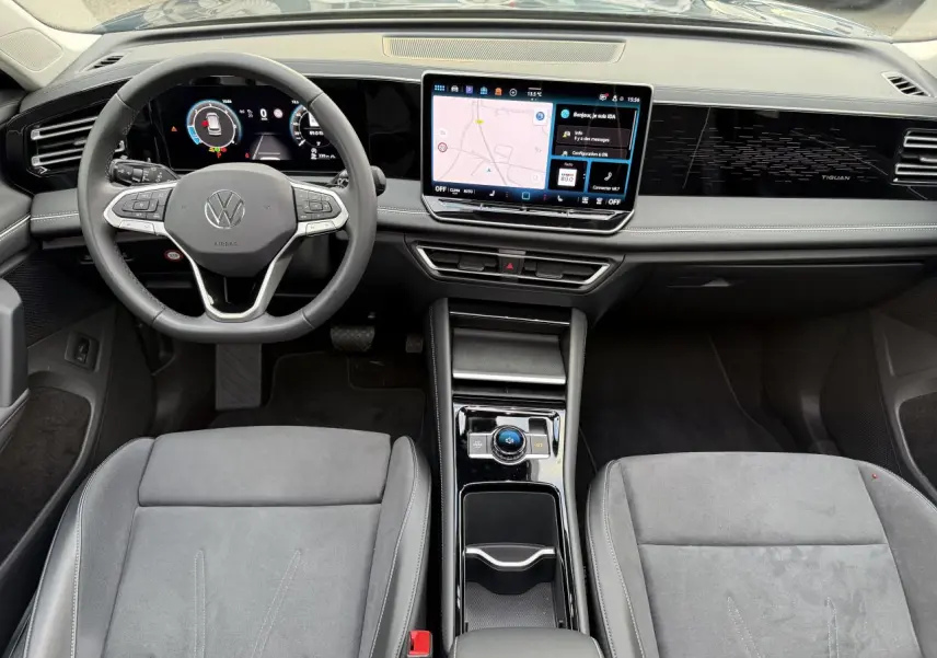 Vue intérieure avant du Volkswagen Tiguan 2024 avec tableau de bord numérique et écran tactile central lumineux.