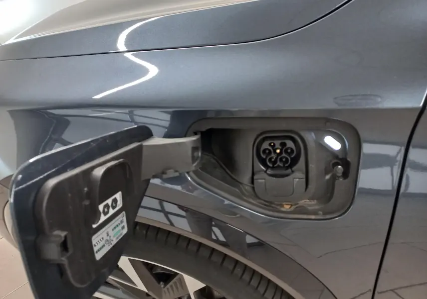 Prise de recharge ouverte côté gauche sur CUPRA Formentor gris magnétique, vue rapprochée sur la trappe et la roue arrière.