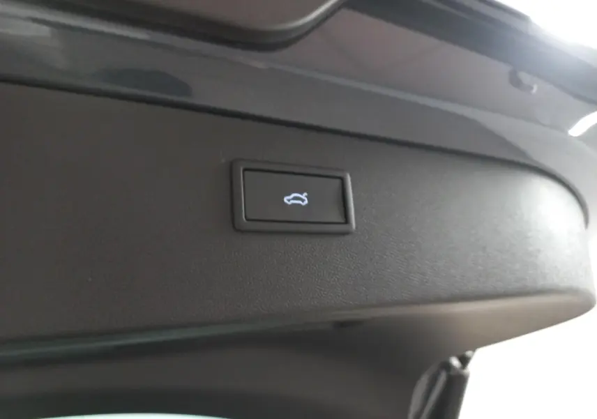 Bouton d'ouverture électrique du coffre sur la partie intérieure du hayon d'un CUPRA Formentor gris magnétique.